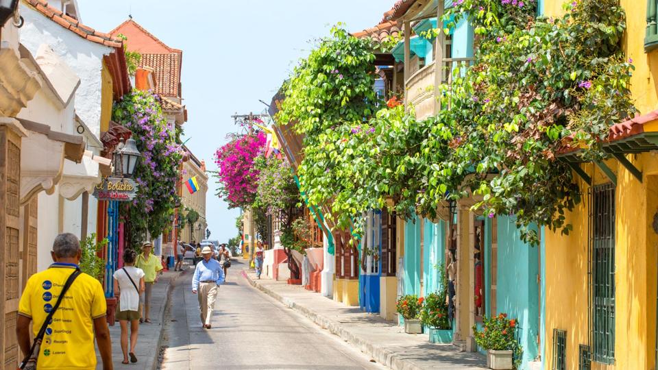 Colourful colonial street in Cartagena draped in bougainvillea