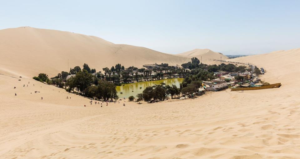 Huacachina oasis surrounded by huge sand dunes