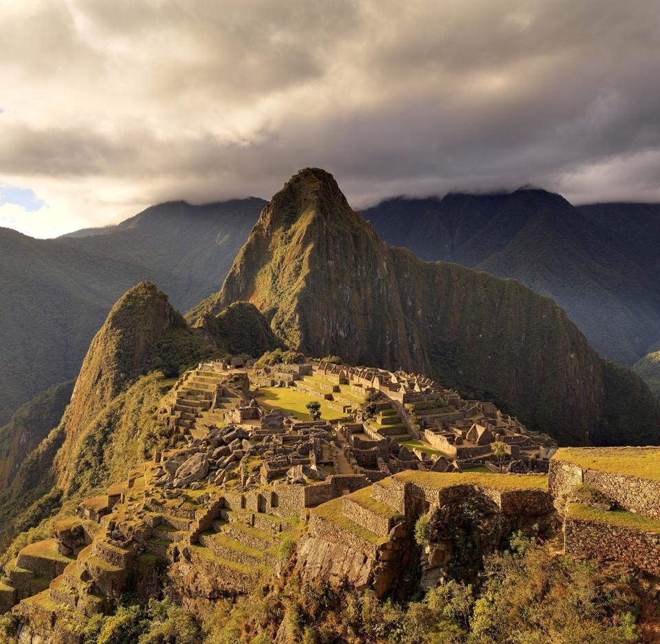 Machu Picchu with Huayna Picchu behind under dramatic clouds