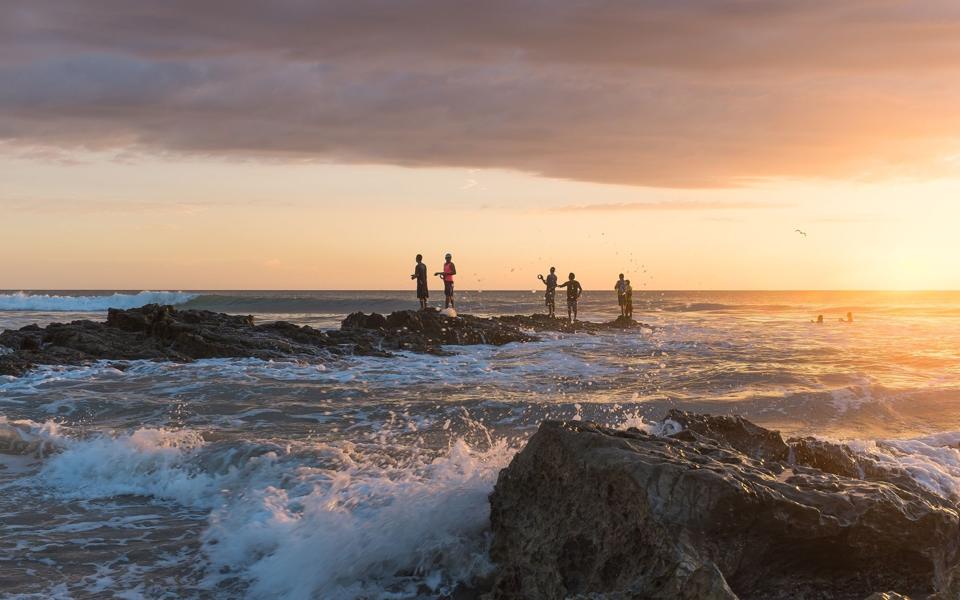Fishermen on rocks at sunset, Playa Santa Teresa